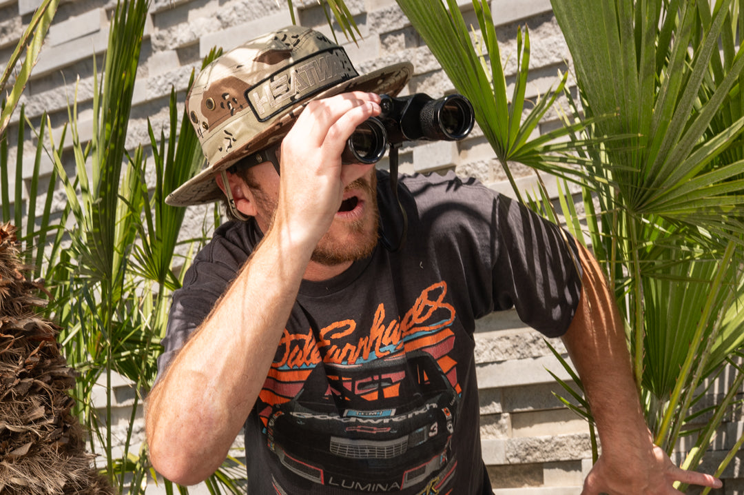 Man with binoculars wearing Heat Wave desert camo boonie hat.