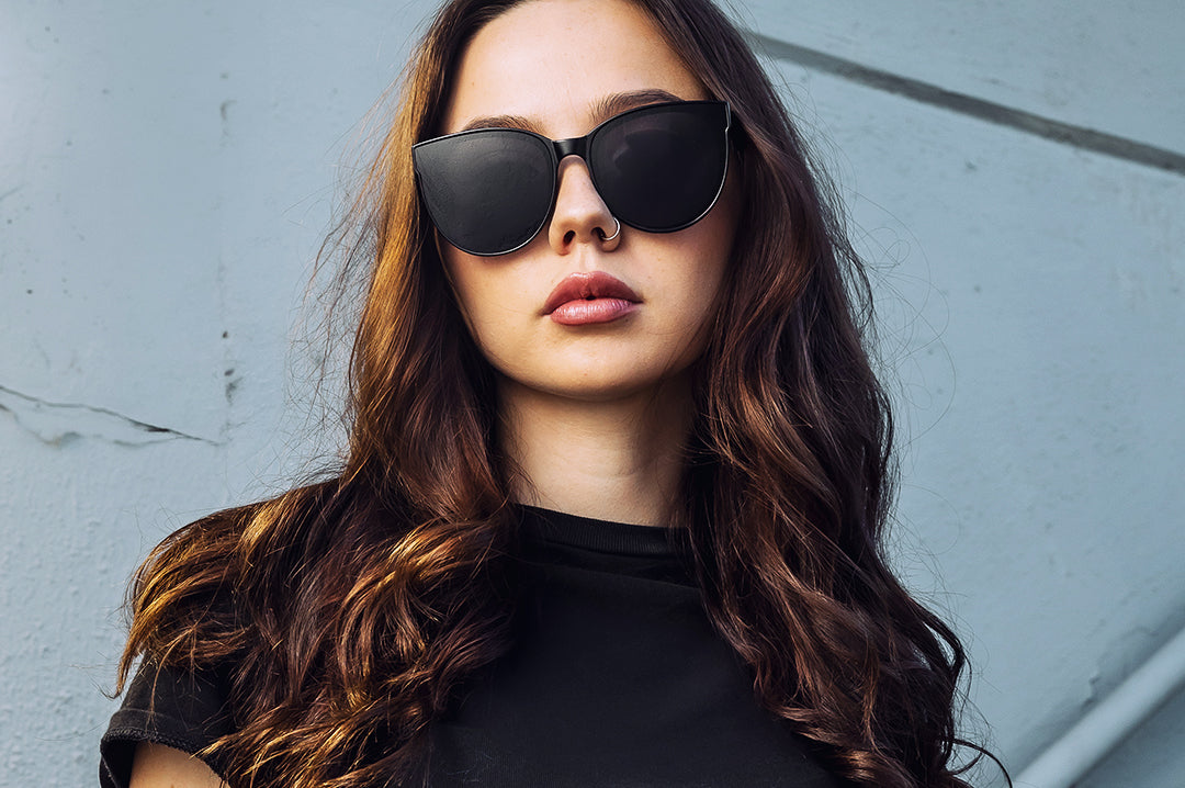 Young women rocking the Heat Wave Visual Carat Sunglasses with black frame and ultra black lenses.
