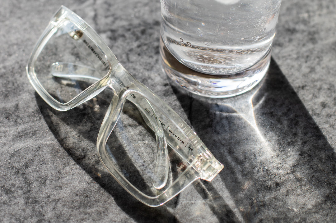 Heat Wave Visual XL Vise Sunglasses with clear frame and clear lenses on a granite table.