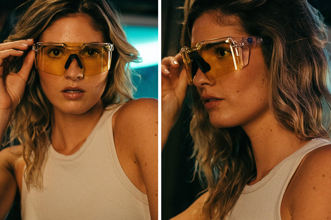 Young woman wearing Heat Wave Visual Future Tech Sunglasses with clear frame and hi vis yellow lens.