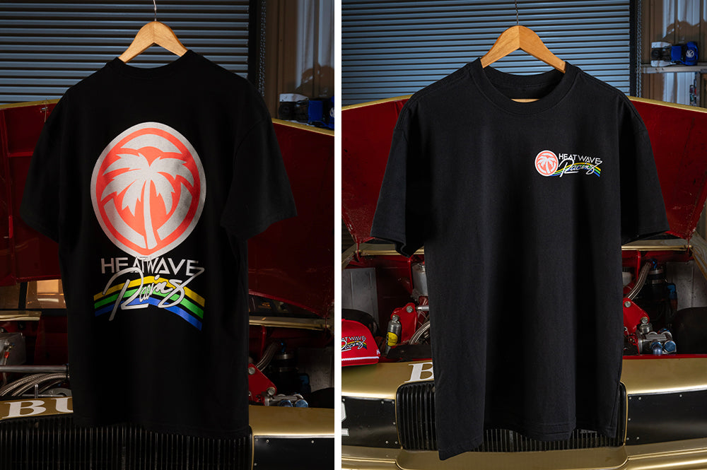 The Heat Wave Visual Trading Paint Black T-shirt in front of the Nascar.