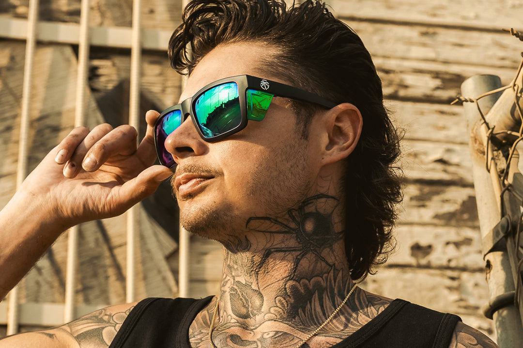 Tattooed man wearing the Heat Wave Performance Vise safety sunglasses with green lenses and green protective side shields.